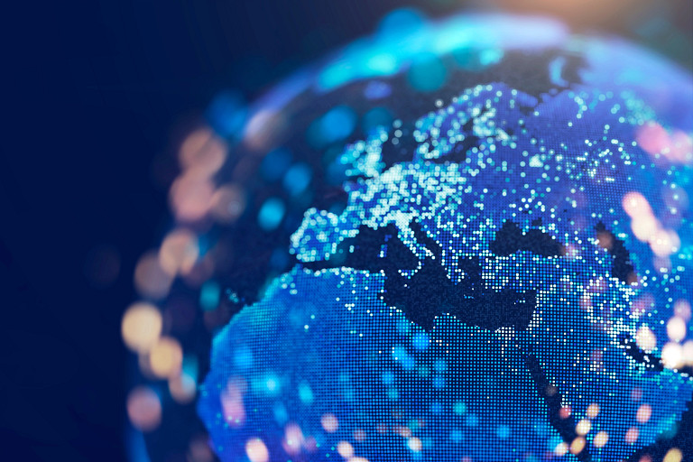 A blurry digital globe, with a map of part of the earth made up of blue dot lights
