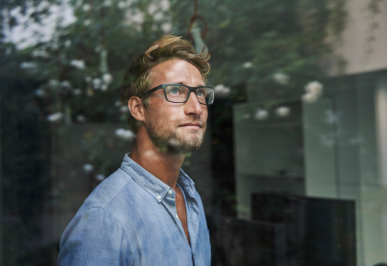 man staring out window